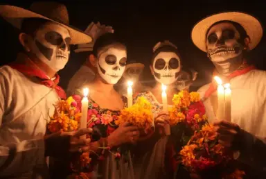 Fotografía de cuatro catrinas con ofrendas